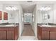 Bathroom vanity with a double sink, cabinets, and a view into the carpeted bedroom at 4730 Se 31St St, Ocala, FL 34480