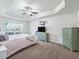 Spacious main bedroom with tray ceiling, fan and carpet flooring at 4730 Se 31St St, Ocala, FL 34480