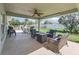 Inviting covered patio featuring comfortable seating, ceiling fan, and views of the lush backyard at 4730 Se 31St St, Ocala, FL 34480