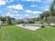 Relaxing pool area featuring a stone water feature, chairs, and a safety fence, set in a well-manicured and spacious backyard at 4730 Se 31St St, Ocala, FL 34480