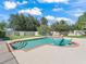 Inviting swimming pool area featuring a stone water feature, two Adirondack chairs, and a well-maintained grassy yard at 4730 Se 31St St, Ocala, FL 34480