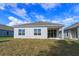 New home backyard with a simple lawn and a covered patio with sliding glass doors at 5009 Balsam Falls Rd, Deland, FL 32724