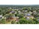 Neighborhood aerial view with mature trees, nearby houses, and a lake in the distance at 501 Cherry Tree St, Eustis, FL 32726