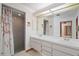 Bathroom featuring dual sinks, a shower with curtain, and ample lighting at 501 Cherry Tree St, Eustis, FL 32726