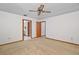 Spacious bedroom with neutral carpeting, ceiling fan, and doors to the ensuite bathroom and closet at 501 Cherry Tree St, Eustis, FL 32726