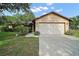 Welcoming one-story home with a two-car garage, green lawn, and established landscaping at 501 Cherry Tree St, Eustis, FL 32726