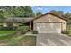 Inviting one-story home featuring a two-car garage, manicured lawn, and mature landscaping at 501 Cherry Tree St, Eustis, FL 32726