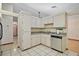 Well-lit kitchen with white cabinets, stainless steel dishwasher and sink, and tile floor at 501 Cherry Tree St, Eustis, FL 32726