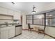 Cozy kitchen area with white cabinets, stainless steel dishwasher and sink, and view to a dining area with lots of light at 501 Cherry Tree St, Eustis, FL 32726