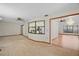 Open concept living area with tan carpeting and a view of the kitchen and dining room at 501 Cherry Tree St, Eustis, FL 32726