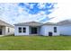 Backyard view of the home with a well-maintained lawn and a sliding glass door at 5013 Balsam Falls Rd, Deland, FL 32724