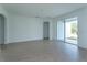 Spacious living room featuring wood-look tile flooring and sliding glass doors to the backyard at 5013 Balsam Falls Rd, Deland, FL 32724