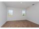 Bright bedroom featuring wood-look floors and two windows with views of the outdoors at 5017 Balsam Falls Rd, Deland, FL 32724