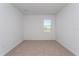 Neutral bedroom with plush carpet, ample natural light through one window, and white walls at 5017 Balsam Falls Rd, Deland, FL 32724