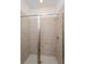 Walk-in shower featuring beige tiling, a glass door, and a rainfall shower head at 5017 Balsam Falls Rd, Deland, FL 32724