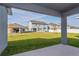 Backyard view from the covered patio with green grass and new homes at 5036 Balsam Falls Rd, Deland, FL 32724
