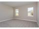A bright bedroom with plush carpet and natural light from two windows at 5036 Balsam Falls Rd, Deland, FL 32724