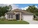 Charming single-story home with stone accents, a two-car garage, and lush landscaping at 5036 Balsam Falls Rd, Deland, FL 32724