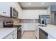 Well-appointed kitchen with white cabinets, stainless appliances, gray subway tile backsplash, and modern fixtures at 5036 Balsam Falls Rd, Deland, FL 32724