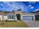 Charming single-story home featuring stone accents, a two-car garage, and beautifully landscaped front yard at 5037 Balsam Falls Rd, Deland, FL 32724