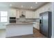 Beautiful kitchen featuring stainless steel appliances, a center island, white cabinets, and tile flooring at 5037 Balsam Falls Rd, Deland, FL 32724