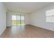 Bright living room with wood-look tile flooring, large sliding glass doors to Lanai, and neutral paint at 5037 Balsam Falls Rd, Deland, FL 32724