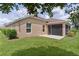 Backyard of home with a screened-in lanai and lush green grass at 5944 Hickey Way, The Villages, FL 32163
