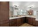 Bathroom with dual sink vanity, granite counters, and decorative mosaic tile at 5944 Hickey Way, The Villages, FL 32163