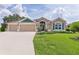 Charming single-story home with a three-car garage, manicured lawn, and a welcoming front entrance at 5944 Hickey Way, The Villages, FL 32163