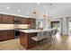 Kitchen boasts an island with seating, modern pendant lights, and sleek stainless steel appliances at 5944 Hickey Way, The Villages, FL 32163