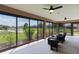 The screen lanai boasts relaxing seating, ceiling fans, and a great view of a pond at 5944 Hickey Way, The Villages, FL 32163