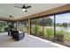 The screened lanai has a ceiling fan and a beautiful view of the yard and a pond at 5944 Hickey Way, The Villages, FL 32163