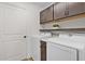 Well-organized laundry room with upper cabinets, countertop space, and a modern washer and dryer at 5944 Hickey Way, The Villages, FL 32163