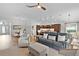 Spacious living room with light wood flooring, plush seating, and an open view of the kitchen at 5944 Hickey Way, The Villages, FL 32163
