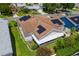 Aerial view of home with solar panels, a screened in patio, and a lush yard in a neighborhood setting at 735 Palma Dr, Lady Lake, FL 32159