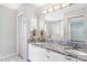 Bathroom with double sinks and granite countertops, and a large mirror reflecting the bathtub at 735 Palma Dr, Lady Lake, FL 32159