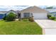 Inviting home featuring lush green lawn and a two-car garage with attractive driveway at 735 Palma Dr, Lady Lake, FL 32159