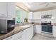 Updated kitchen with white cabinets, granite countertops, and stainless steel appliances at 735 Palma Dr, Lady Lake, FL 32159