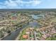 Aerial showcases a water front community with houses along golf course, lakes, and lush greenery at 780 Mystic Hill Ct, Kissimmee, FL 34759