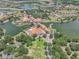 Aerial view of the community clubhouse nestled along the water, featuring beautiful architecture and resort-style amenities at 780 Mystic Hill Ct, Kissimmee, FL 34759