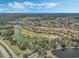 An aerial view shows the lush community around golf course and beautiful lakes under a partly cloudy sky at 780 Mystic Hill Ct, Kissimmee, FL 34759