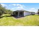 Spacious yard showing the screened-in lanai, and mature landscaping at 780 Mystic Hill Ct, Kissimmee, FL 34759