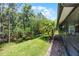 Backyard showing the lanai, mature landscaping, and the side of the house at 780 Mystic Hill Ct, Kissimmee, FL 34759
