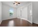 Bright bedroom with wood floors, ceiling fan and a window with a view of palm trees at 780 Mystic Hill Ct, Kissimmee, FL 34759