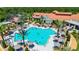 Expansive community pool with lounge chairs and umbrellas, surrounded by palm trees and a beautifully designed clubhouse at 780 Mystic Hill Ct, Kissimmee, FL 34759
