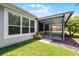Exterior view of screened-in lanai, backyard with lush landscaping and a window at 780 Mystic Hill Ct, Kissimmee, FL 34759