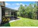 Screened-in lanai surrounded by lush greenery and well-manicured lawn at 780 Mystic Hill Ct, Kissimmee, FL 34759