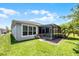 Back exterior showing a screened-in lanai, and a well kept lawn at 780 Mystic Hill Ct, Kissimmee, FL 34759