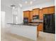 Kitchen island with seating featuring cabinets, black countertops, stainless sink, and pendant lights at 780 Mystic Hill Ct, Kissimmee, FL 34759