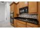 Close-up of kitchen with maple cabinetry, granite countertops, and stainless steel appliances at 780 Mystic Hill Ct, Kissimmee, FL 34759